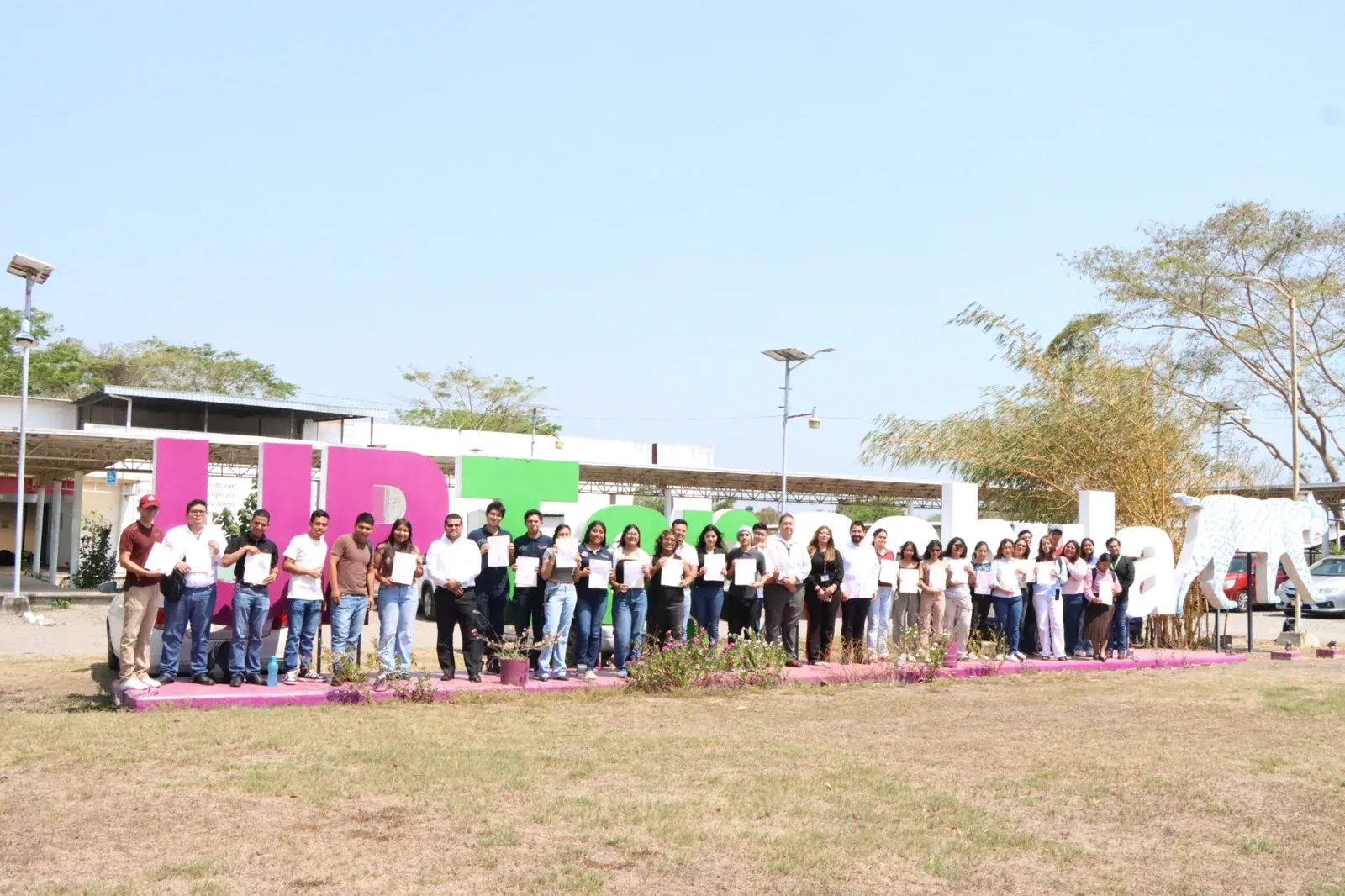 Students and faculty in front of the UPTap monumental letters on the Tapachula campus.